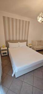 a large white bed in a bedroom with a chandelier at APPARTAMENTO A DUE PASSI DAL MARE By VILLA FIORITA in Cattolica