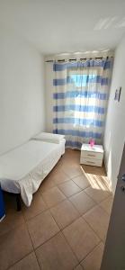a small bedroom with a bed and a window at APPARTAMENTO A DUE PASSI DAL MARE By VILLA FIORITA in Cattolica +1 photo