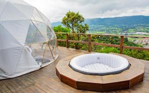 una cupola di vetro situata sopra un ponte di legno di Glamping Yáku a Tenjo