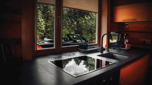 a kitchen counter with a sink and a window at Bērzi in Turkalne +25 photos