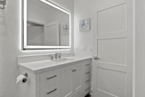a white bathroom with a sink and a mirror at Miramar Oasis - Ocean View, Steps2Beach, Roof Deck in El Granada +30 photos