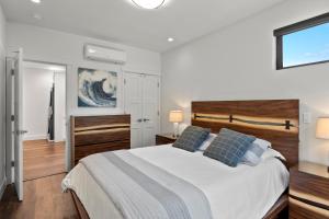 a bedroom with a large white bed with blue pillows at Miramar Oasis - Ocean View, Steps2Beach, Roof Deck in El Granada +30 photos