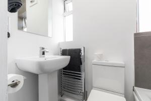海丁利Stylish Studio Apt in Leeds的带水槽和马桶的白色浴室