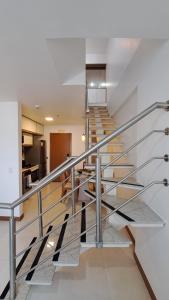 a staircase with stainless steel railings in a house at Athos Bulcão - Cobertura Duplex - Un 1519 in Brasilia