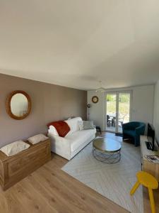 a living room with a white couch and a table at maison proche de granville in Longueville