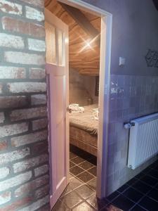 a room with a brick wall and a bedroom at Betuwsch Badhuys in Lienden +13 photos