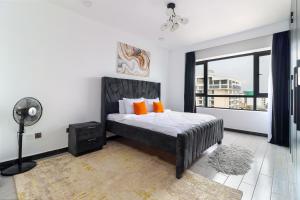 - une chambre avec un lit doté d'oreillers orange et d'un ventilateur dans l'établissement Nyumbani Oasis - Tastefully Furnished Three Bedroom Apartment In Kilimani, à Nairobi 18 autres photos