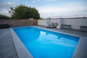 a large blue swimming pool on a wooden deck at Willa Świniarsko z basenem in Podrzecze