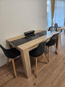 une table en bois avec quatre chaises dans une chambre dans l'établissement Maison avec jardin proche gare, à Belleville-en-Beaujolais