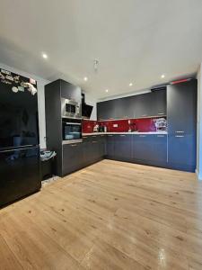 une grande cuisine avec des armoires bleues et un plancher en bois dans l'établissement Maison avec jardin proche gare, à Belleville-en-Beaujolais