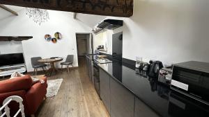 a kitchen with black countertops and a table and chairs at The Smithy in Knaresborough