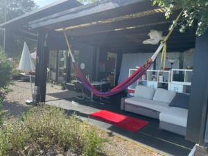 a porch with a hammock in a house at Graine de Paradis - Tiny House in Le Landeron