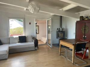 a living room with a couch and a table at Graine de Paradis - Tiny House in Le Landeron