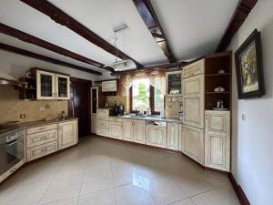 a large kitchen with white cabinets and a window at Willa Świniarsko z basenem in Podrzecze