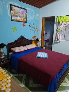 une chambre avec un grand lit recouvert d'une couverture rouge dans l'établissement Happy Hour no Condo- Minions, à Riacho Grande