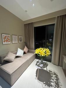 a living room with a couch and a table with yellow flowers at Homestay Huế ơi 2 in Thôn Văn Dương +42 photos