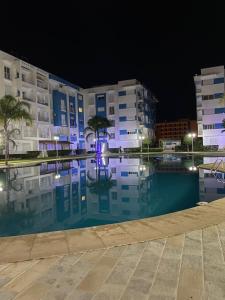 a night view of a building with a swimming pool at Belle Appartement & Résidence Avec Piscine& A 10min de la plage- Martil-Tétouan in Martil
