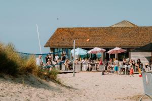 a group of people sitting at a bar on the beach at Glamping Boszee in Middelkerke
