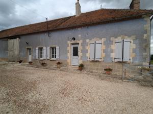 a gray building with white doors and windows at Gîte familial rénové avec jardin, proche forêt d'Orléans et activités, à 1h d'Orléans et 2h de Paris - FR-1-590-439 in Fréville-du-Gâtinais