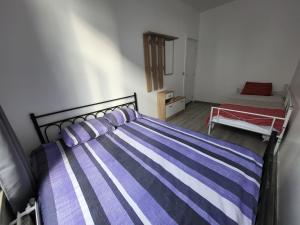 - une chambre avec un lit à rayures violettes et blanches dans l'établissement Appart Bruxelles Midi Station, à Bruxelles