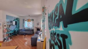a living room with a couch and a living room with a wall at Baleal GuestHouse - Yoga included in Baleal