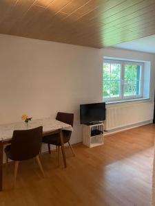 un soggiorno con un tavolo e una TV di Schöne Ferienwohnung in Top Lage a Wiggensbach