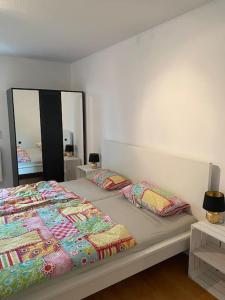 una camera da letto con un letto con due cuscini e uno specchio di Schöne Ferienwohnung in Top Lage a Wiggensbach