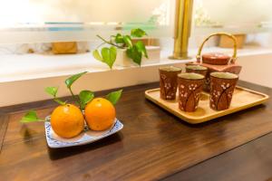 due piatti di arance su un tavolo con tazze di Flower Bird House B&B a Jiaoxi