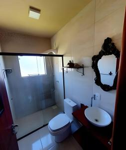 a bathroom with a toilet and a shower and a sink at Chalé da Montanha com Ofurô in Santo Amaro da Imperatriz