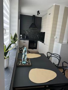 Una cocina con una mesa con una botella de agua encima. en Apartament Duet, en Kłodzko