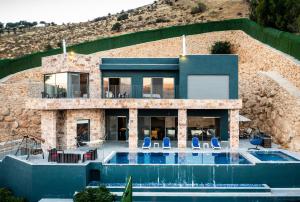 a house with a swimming pool in front of a building at Makanak Villas in Jerash