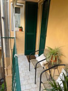 a porch with two chairs and a green door at Stasera da me in Pisa