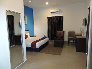 ein Hotelzimmer mit einem Bett und einem Spiegel in der Unterkunft Royal Agate Beach Resort in Pantai Cenang