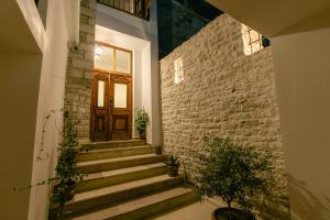 a stairway with a wooden door and a brick wall at Petrichor in Gjirokastër