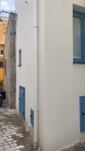 a white building with blue doors on the side of it at Casa n'to strittu in Lipari