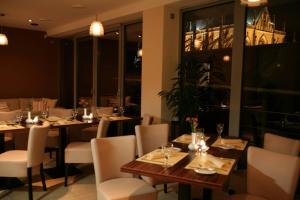 a restaurant with tables and chairs with a view of the city at Penzion a Restaurant Barbora in Kutná Hora