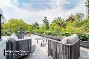 a balcony with chairs and tables and trees at Capitalia Parque Lincoln in Mexico City