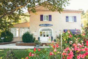a house with flowers in front of it at Logis Hôtel La Magnanerie - Côté Bistro in Aubignosc