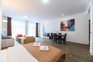 a hotel room with a bed and a dining room at Alpine Escape Studio - Silver Mountain Resort & SPA - Poiana Brasov in Poiana Brasov +22 photos