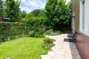 a backyard with a lawn and a fence at Beautifully located dune villa near Noordwijk beach in Noordwijk