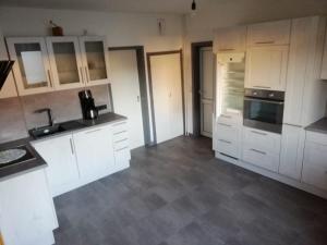 an empty kitchen with white cabinets and appliances at Bimbacher Betten in Bimbach