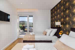 ein Schlafzimmer mit einem Bett und einer Couch und einem Balkon in der Unterkunft Villa dal' Mares in Vinišće + 111 Fotos