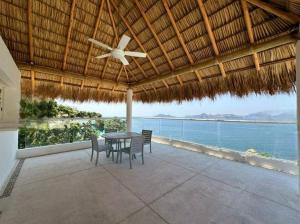 a patio with a table and chairs and the ocean at Villa MAJUM Acapulco in Acapulco