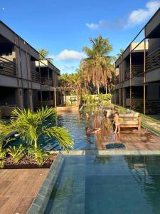 a swimming pool in a building with people in the water at Villa Kamby Milagres B003 in São Miguel dos Milagres