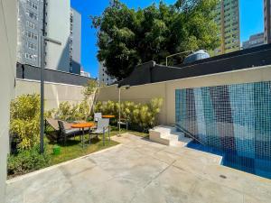 eine Terrasse mit Tisch und Stühlen auf einem Gebäude in der Unterkunft Handy Paraíso condomínio com piscina ao lado do Ibirapuera in São Paulo