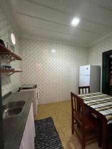 a kitchen with a sink and a table and a refrigerator at Casa da Matriz Centro Histórico in Paraty