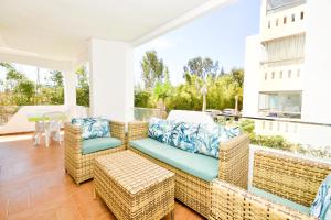 un patio con sedie in vimini e un divano sul balcone. di Modern Marina - Beach - Pool a Sidi Rahal