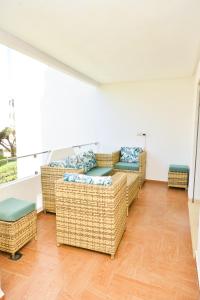 un soggiorno con divani in vimini e un balcone di Modern Marina - Beach - Pool a Sidi Rahal