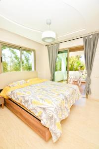 una camera da letto con un letto grande in una stanza con finestre di Modern Marina - Beach - Pool a Sidi Rahal