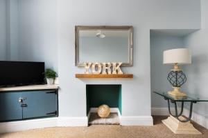 un soggiorno con camino e specchio di Ebor Place - Stunning Period Home With Free Parking a York